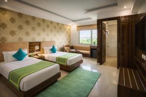 a hotel room with two beds and a bathroom at OPO Horizon LYRO Hotel , Formerly known as Inde Hotel in Gurgaon
