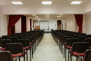 an empty lecture room with black chairs and a screen at Hotel N in Belgrade