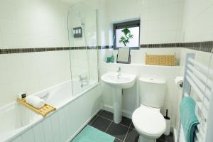 a white bathroom with a toilet and a sink at Spacious City Centre Apartment with Balcony in Wolverhampton +6 photos