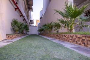 a corridor of a building with palm trees and plants at Al Muhaidb Residence Al Malaz 3 - Economic in Riyadh