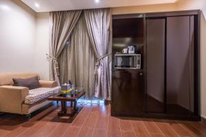 a living room with a couch and a refrigerator with a microwave at Al Muhaidb Residence Al Malaz 3 - Economic in Riyadh