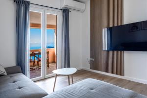 a living room with a couch and a view of the ocean at Apartments Mrkan 2 in Cavtat