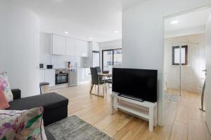 a living room with a large flat screen tv at Central Condo-Pool with AC and garden by Algarve Dream Holidays in Albufeira