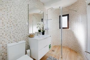 a bathroom with a toilet and a sink and a mirror at Central Condo-Pool with AC and garden by Algarve Dream Holidays in Albufeira +10 photos