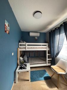 a bedroom with blue walls and a white bunk bed at Casa Barmalei Private Pool & Rooftop Terrace Ocean View, Tenerife in Callao Salvaje