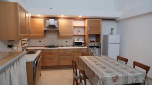 a kitchen with a table and a white refrigerator at La casa del tulipano in Bernalda
