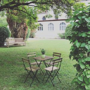 a table and chairs in a yard with a bench at Kloster Altenhohenau FHN in Griesstätt