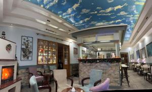 a restaurant with a mural of clouds on the ceiling at Garni Hotel Lav in Belgrade