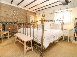 a bedroom with a metal bed and a table at In & Out Cottage in Leyburn