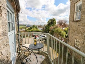 a table with a bottle of wine on a balcony at In & Out Cottage in Leyburn