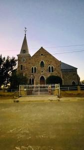 an old stone church with a clock tower on it at Williston Bly of Gly in Williston
