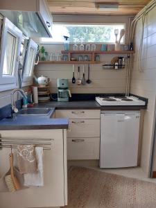 a small kitchen with a sink and a stove at Knus Tiny house 2 pers rust natuur en privacy in Borger