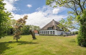 a large white house with a large grass yard at R-1 Hoeve Holland in De Cocksdorp