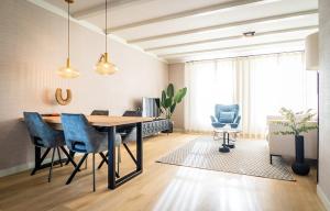 a dining room with a table and blue chairs at R-1 Hoeve Holland in De Cocksdorp