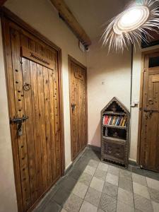 a room with two wooden doors and a book shelf at Riad Atlas Surf in Tamraght Ouzdar