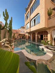 a swimming pool in front of a building at Riad Atlas Surf in Tamraght Ouzdar