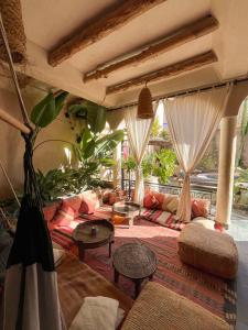 a living room with a couch and tables at Riad Atlas Surf in Tamraght Ouzdar