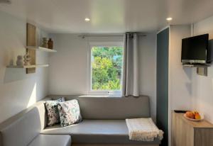 a small living room with a couch and a window at Vista Mare , Cap corse in Meria