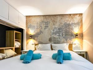 a bedroom with a large white bed with blue pillows at Casa Arno - Lovely Renovated Apartment In Playa De Mogan in Puerto de Mogán +21 photos