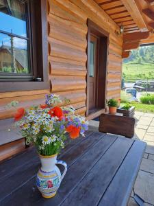 a vase of flowers sitting on a table on a porch at Zrub pod Roháčmi in Zuberec