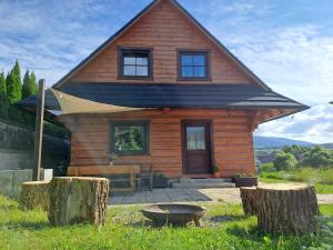 a small wooden house with a porch and a grill at Zrub pod Roháčmi in Zuberec