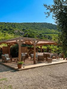 a wooden pavilion with tables and chairs on a patio at Vista Mare , Cap corse in Meria