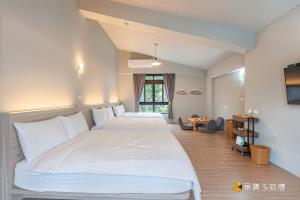 a hotel room with two beds and a television at Bi La Homestay in Luye