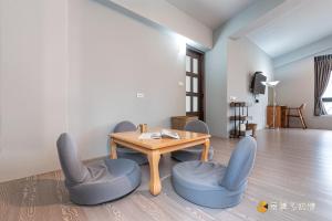 a living room with a wooden table and chairs at Bi La Homestay in Luye