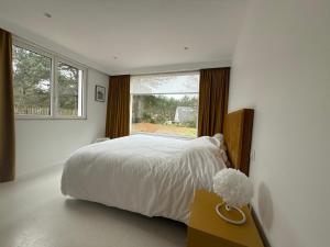 a bedroom with a large bed and a window at Villa la Hune- Proche Golfs & Plage in Neufchâtel-Hardelot