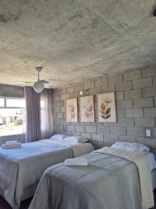 a bedroom with three beds and paintings on the wall at Casa Concept in Mucugê