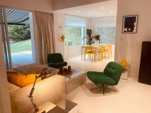 a living room with a couch and chairs and a table at Villa la Hune- Proche Golfs & Plage in Neufchâtel-Hardelot