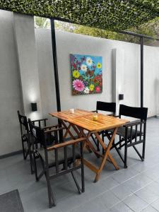 a wooden table and chairs with a painting on the wall at Pepe Hostel Boutique in Neuquén