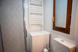 a small bathroom with a toilet and a sink at Casa Celia by CARDI SUITES in Panticosa +25 photos