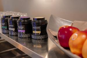 a row of bottles of spices next to a bowl of apples at Hotel Atlanta in Valkenburg +62 photos