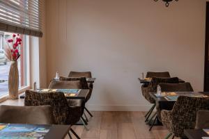 a dining room with tables and chairs and a window at Hotel Atlanta in Valkenburg