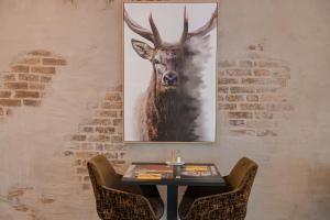 a painting of a deer on a wall with a table at Hotel Atlanta in Valkenburg