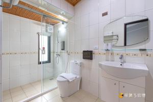 a bathroom with a toilet and a sink and a shower at Bi La Homestay in Luye
