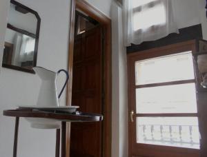 a table with a vase on it next to a door at Fonda la Plaza in Valderrobres