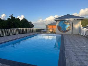 a large blue swimming pool in a yard at Résidence Fleur de Café - Petite Terre in Deshaies +3 photos