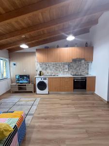 a large kitchen with wooden cabinets and a tv at Casa das Flores in Sardoal