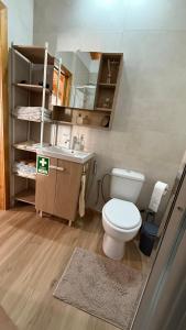 a bathroom with a white toilet and a sink at Casa das Flores in Sardoal