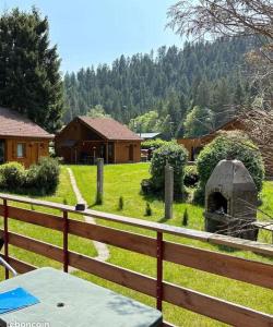 a wooden fence next to a yard with a field at Chalet Lodge - O'Bord de l'Eau in Gérardmer