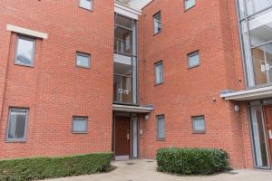 a red brick building with a brown door at Spacious City Centre Apartment with Balcony in Wolverhampton