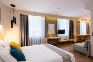 a bedroom with a bed and a couch and a television at St. Bjur Suites in Athens