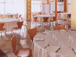 a dining room with tables and chairs with wine glasses at Hotel Planet International in Arezzo