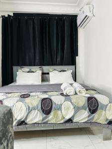 a bedroom with a bed with a black curtain at West Side Résidence in Dakar