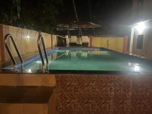 a swimming pool at night with two metal faucets at SAHAY VILLA RESORT in Durbate