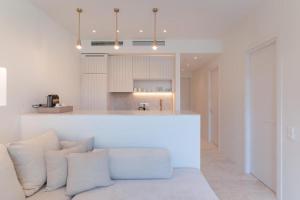 a kitchen with white walls and a counter with pillows at Apartment Athina with direct pool access - GH8 in Gialova