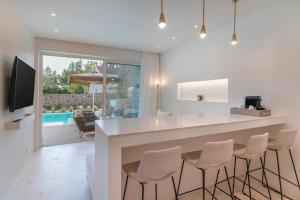 a kitchen with a bar with stools at Apartment Athina with direct pool access - GH8 in Gialova