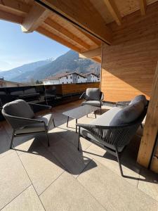a patio with chairs and tables and a view of a mountain at Ahorn Studios in Finsing